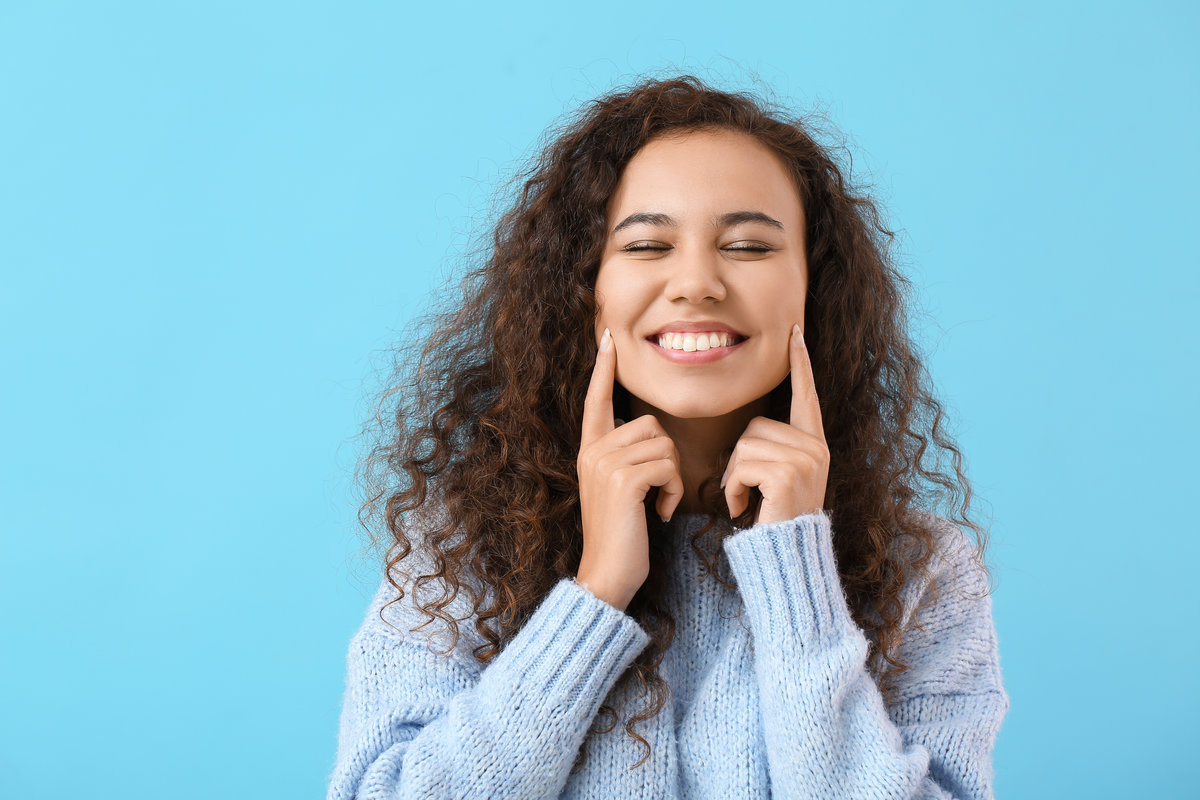 Beautiful young woman with healthy teeth on color background